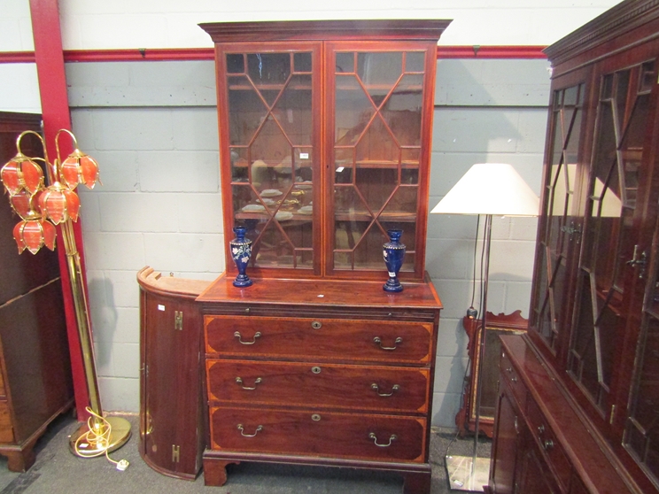 A Georgian mahogany glazed two door bookcase cabinet above a three drawer base with brushing slide,