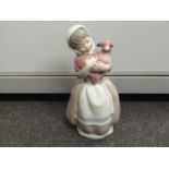 A Lladro figure of a girl holding a lamb,