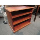 A modern mahogany three-tier entertainments shelf unit