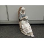 A Lladro seated lady sewing,