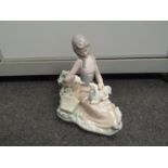 A Lladro figure of a girl feeding a lamb,