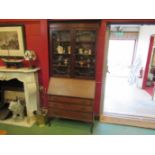 An Edwardian bureau bookcase with glazed top and three drawers on cabriole legs,