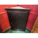 A circa 1830 oak corner cupboard with panelled single door and key,