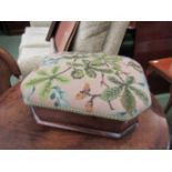 A small Victorian walnut stool with needlepoint upholstery and crossbanded decoration on bun feet,