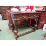 An oak gothic style two drawer hall table on stretcher base,