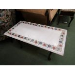 A white marble table-top inlaid with multicoloured floral border, with associated stool as a base,