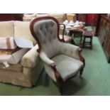 A Victorian walnut spoon back armchair with scroll carved decoration on turned tapering legs and