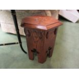 An Arts & Crafts oak hexagonal top lamp table with clover leaf decoration,