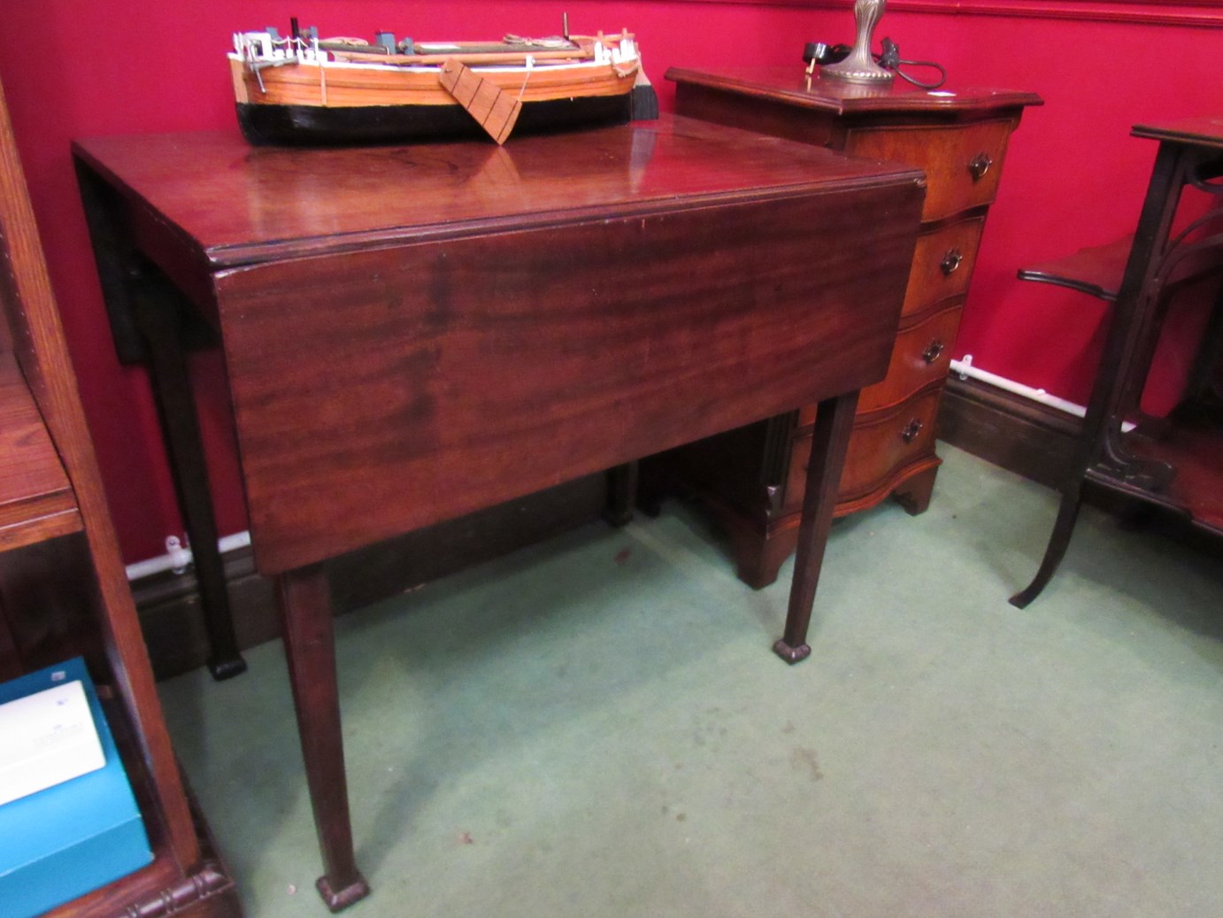 A George III mahogany Pembroke table on chamfered tapering legs and carved feet,