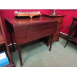 A George III mahogany Pembroke table on chamfered tapering legs and carved feet,