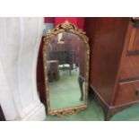 A modern cartouche shaped wall mirror in gilded frame,