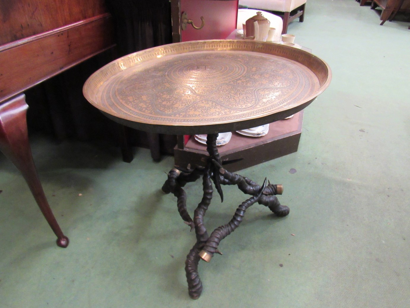 An engraved brass tray top table on ibex horn brass capped base,