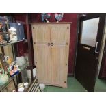 A limed oak gothic style two door wardrobe with fitted interior,