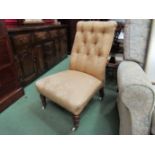 A Victorian nursing chair with gold silk upholstery,