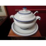 A large lidded soup tureen with ladle on stand