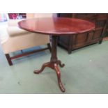 A 19th Century mahogany and oak circular tilt top wine table on cannon barrel turned column and