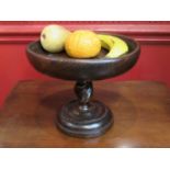 A stained oak dish on barley twist pedestal stand containing painted clay fruit