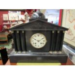 A Victorian black slate mantel clock of architectural form, with key,