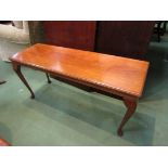 A coffee table with cabriole legs on pad feet,