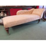 A mid Victorian chaise longue with turned and reeded legs on brass cup castors,