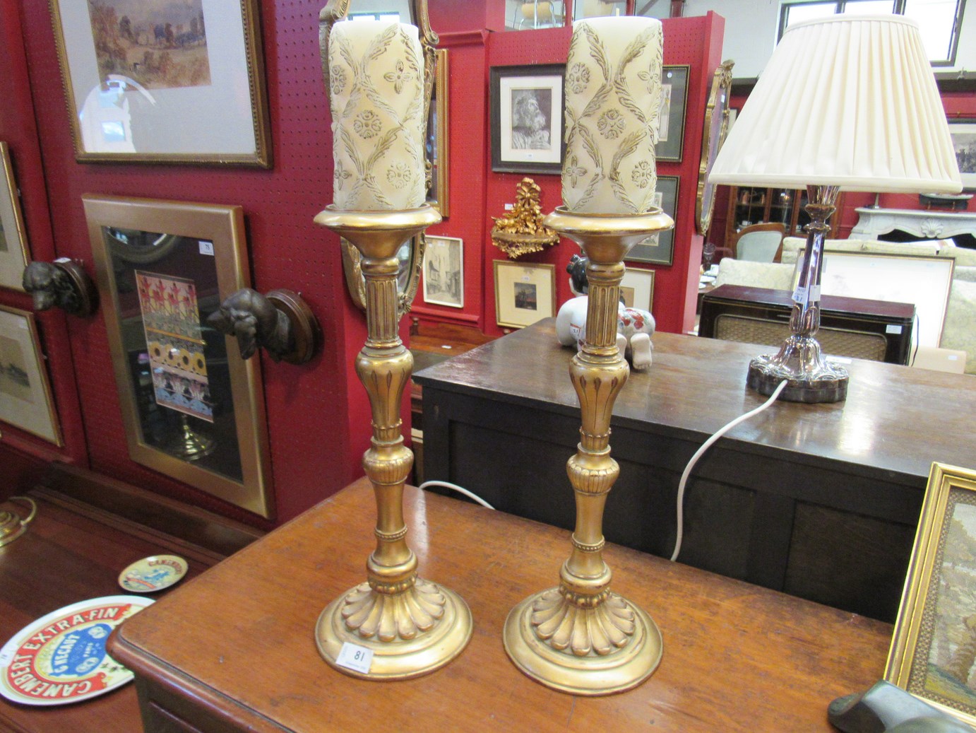 A pair of gilt acanthus leaf candlesticks with ornate candles,