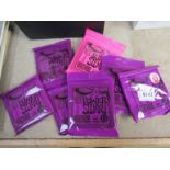 Seven unopened sets of Ernie Ball guitar strings