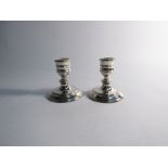 A pair of silver squat form candlesticks, London 1988 filled,