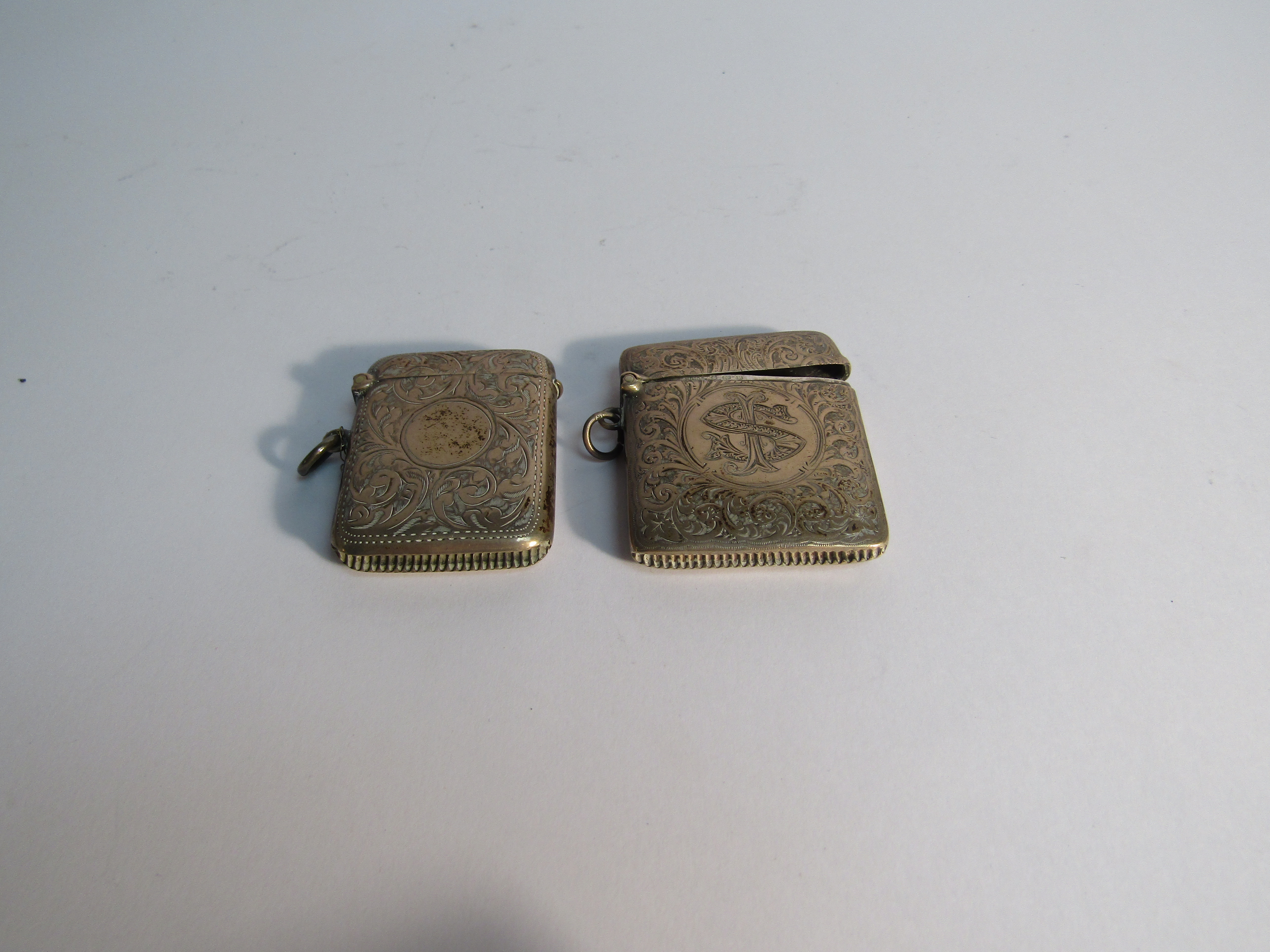Two silver Vesta cases with all over engraved detail, both 5cm tall, one monogrammed,