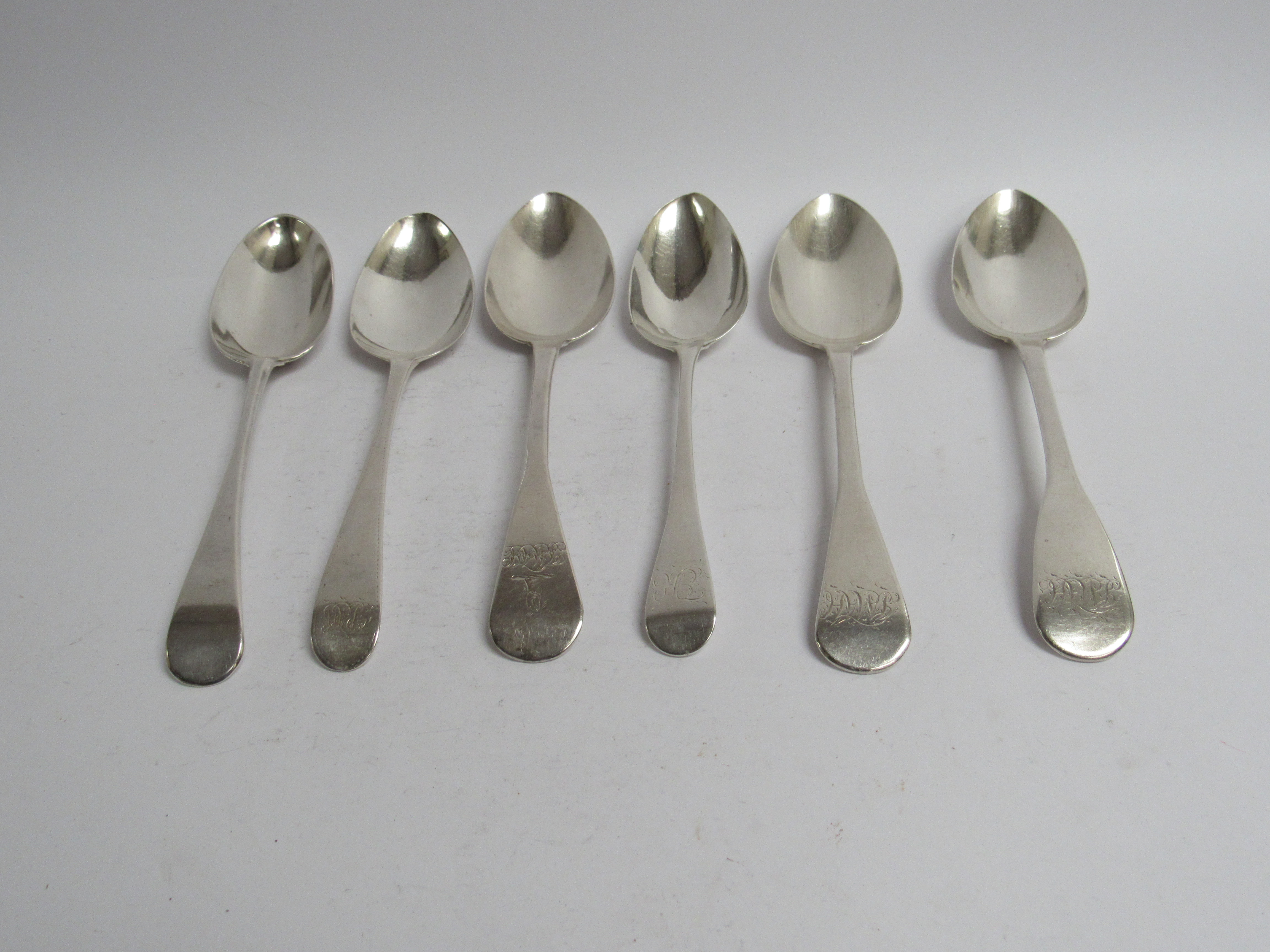 Six various Georgian serving spoons, five with monogrammed handles,