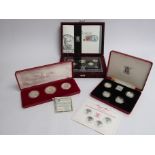 Three proof coin sets including Royal Mint 1984-1987 £1 silver proof collection.