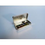 A silver miniature artists paint box with brush and watercolours, makers mark SJR London 2004,