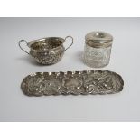 A silver sugar bowl, dressing table tray and hair tidy, dents and splits present,