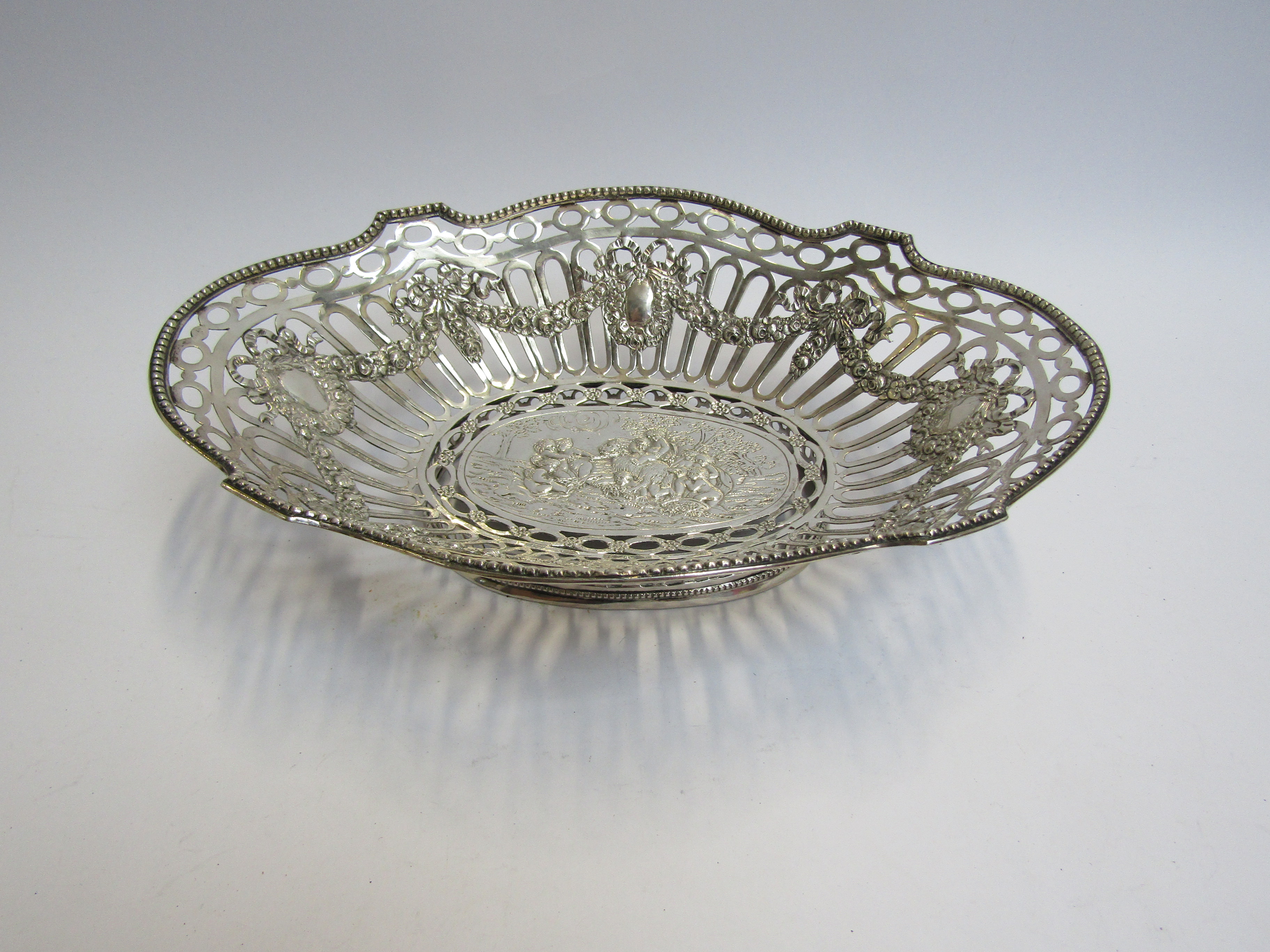 A continental silver pierced basket embossed design, stamped 800, 26cm long x 7cm tall,