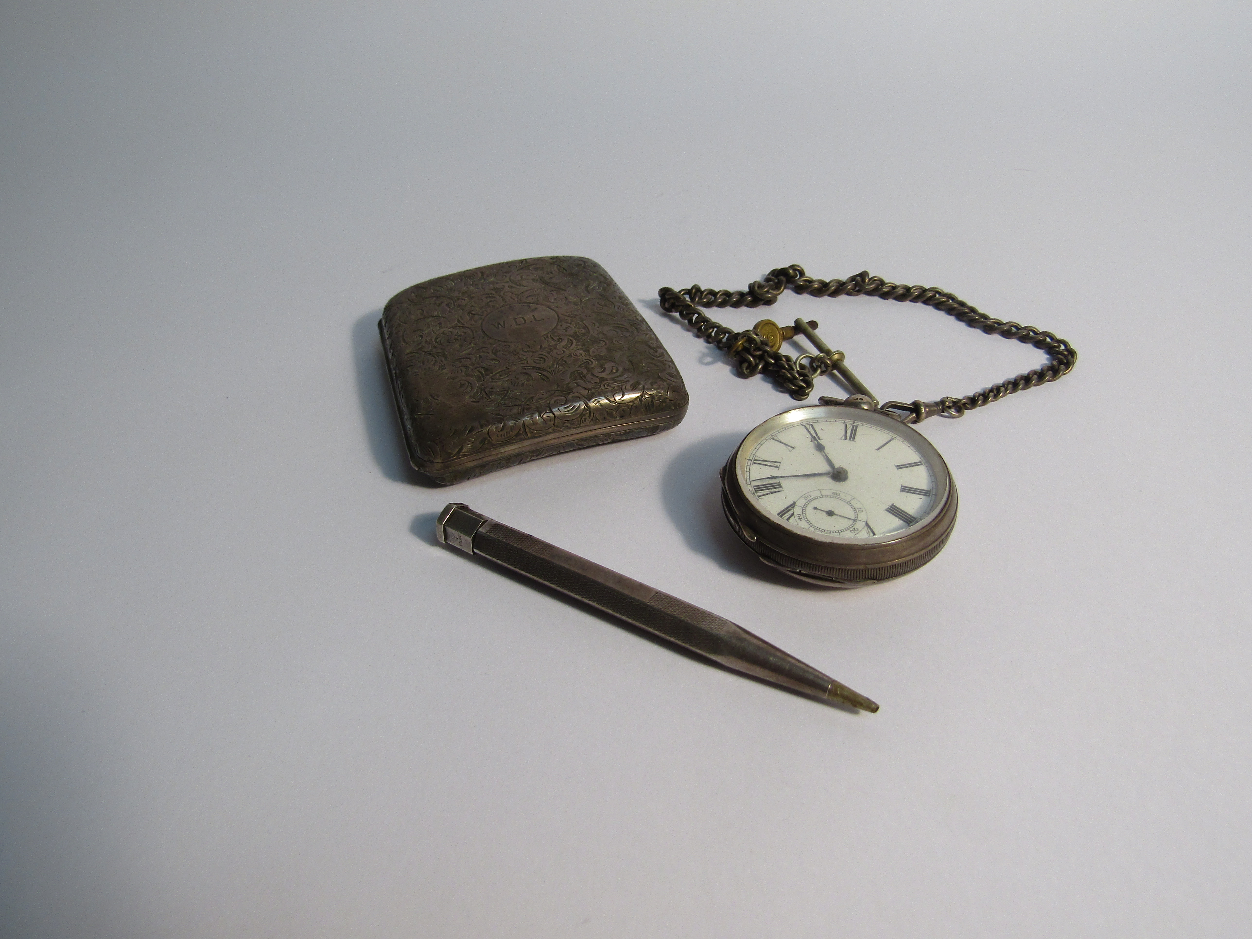 A silver cigarette case, monogrammed and dated,