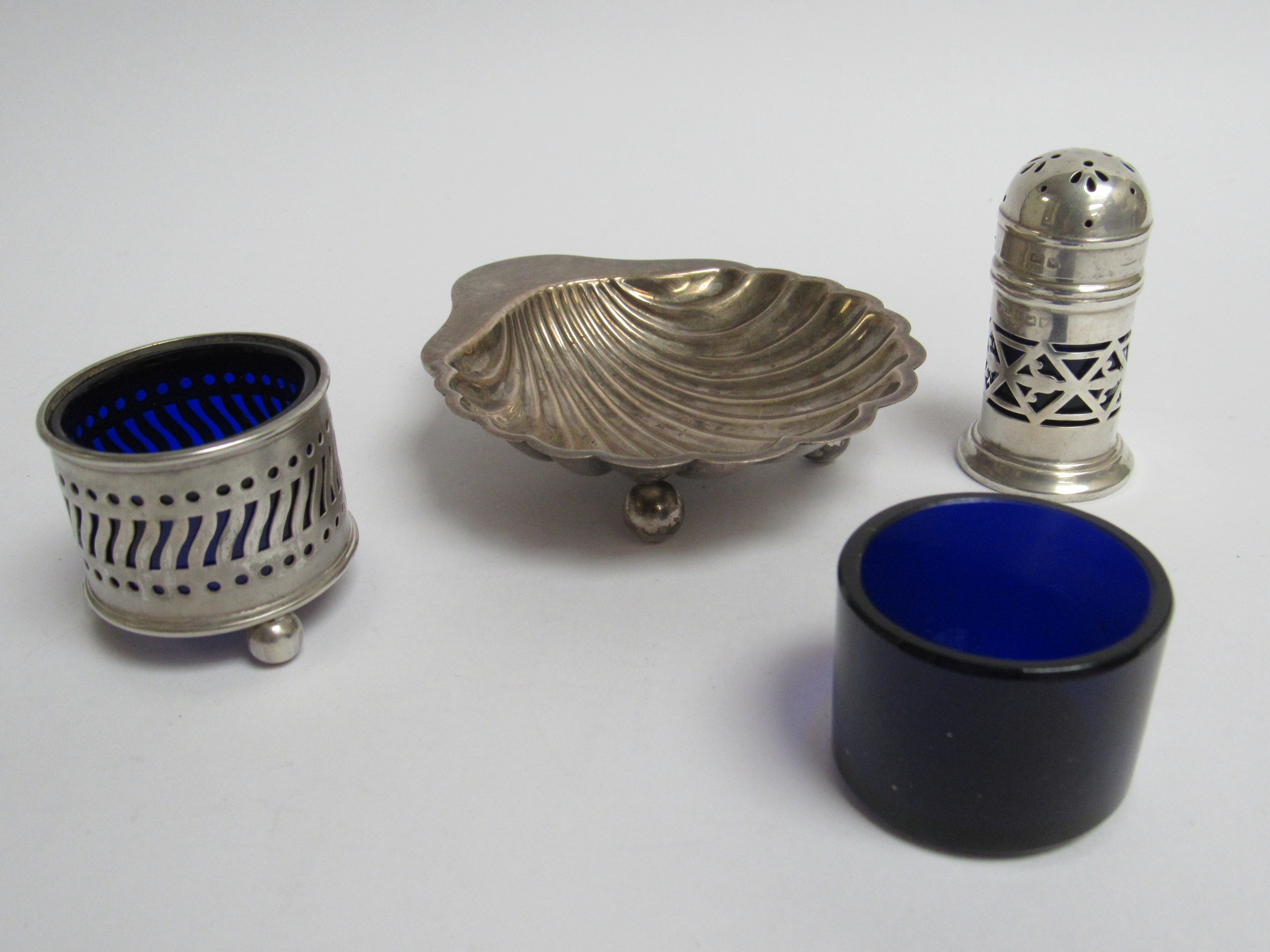 A pierced silver pepperette, salt, scallop form dish and Bristol blue liner,