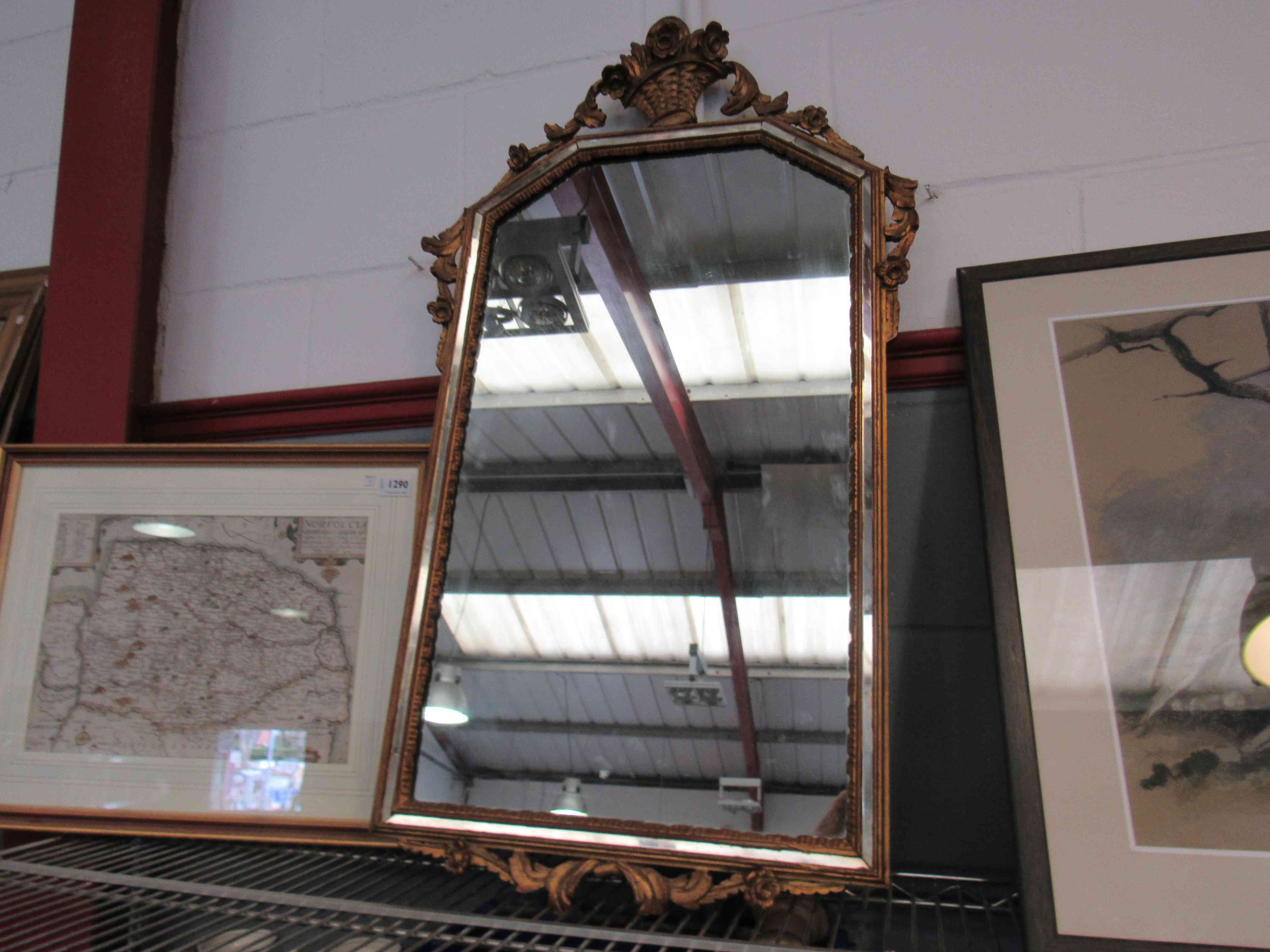 A gilt framed wall mirror with flower basket crest,