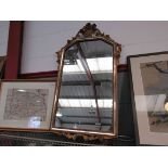 A gilt framed wall mirror with flower basket crest,