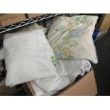 A box of linen and wool cloths, blankets, curtains and cushions etc.