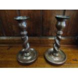 A pair of oak barley twist candlesticks with drip trays,