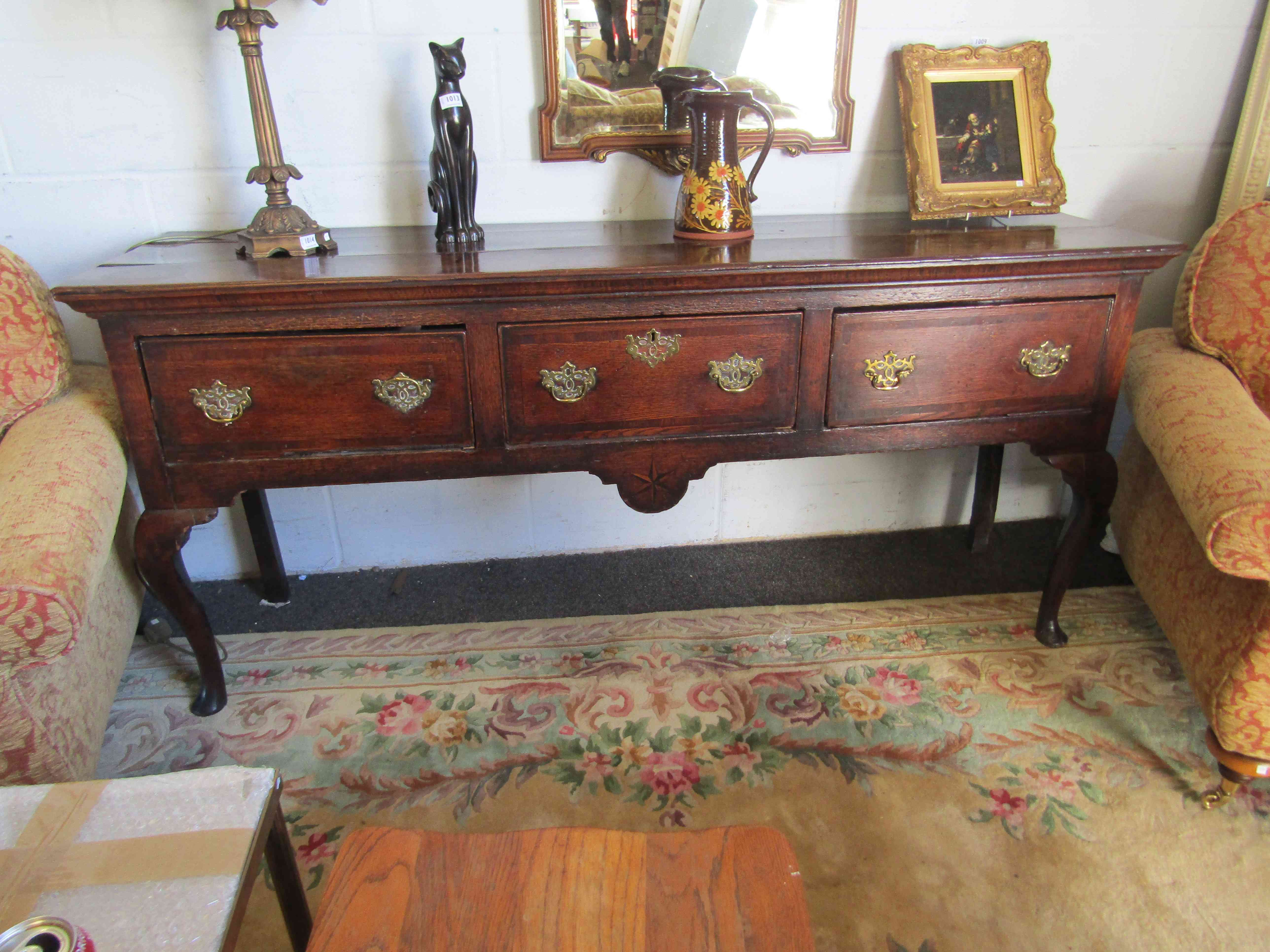 An oak three drawer sideboard on cabriole legs,