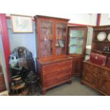 A Georgian mahogany glazed two door bookcase cabinet above a three drawer base with brushing slide,