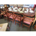 A large mahogany dining table with extra leaf, and six red cushioned chairs and two carvers,