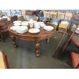 An oak oval extending dining table on baluster legs with two extra leaves