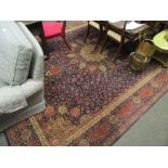 A large wool/silk rug, blue and red ground, central floral motif with multiple borders,