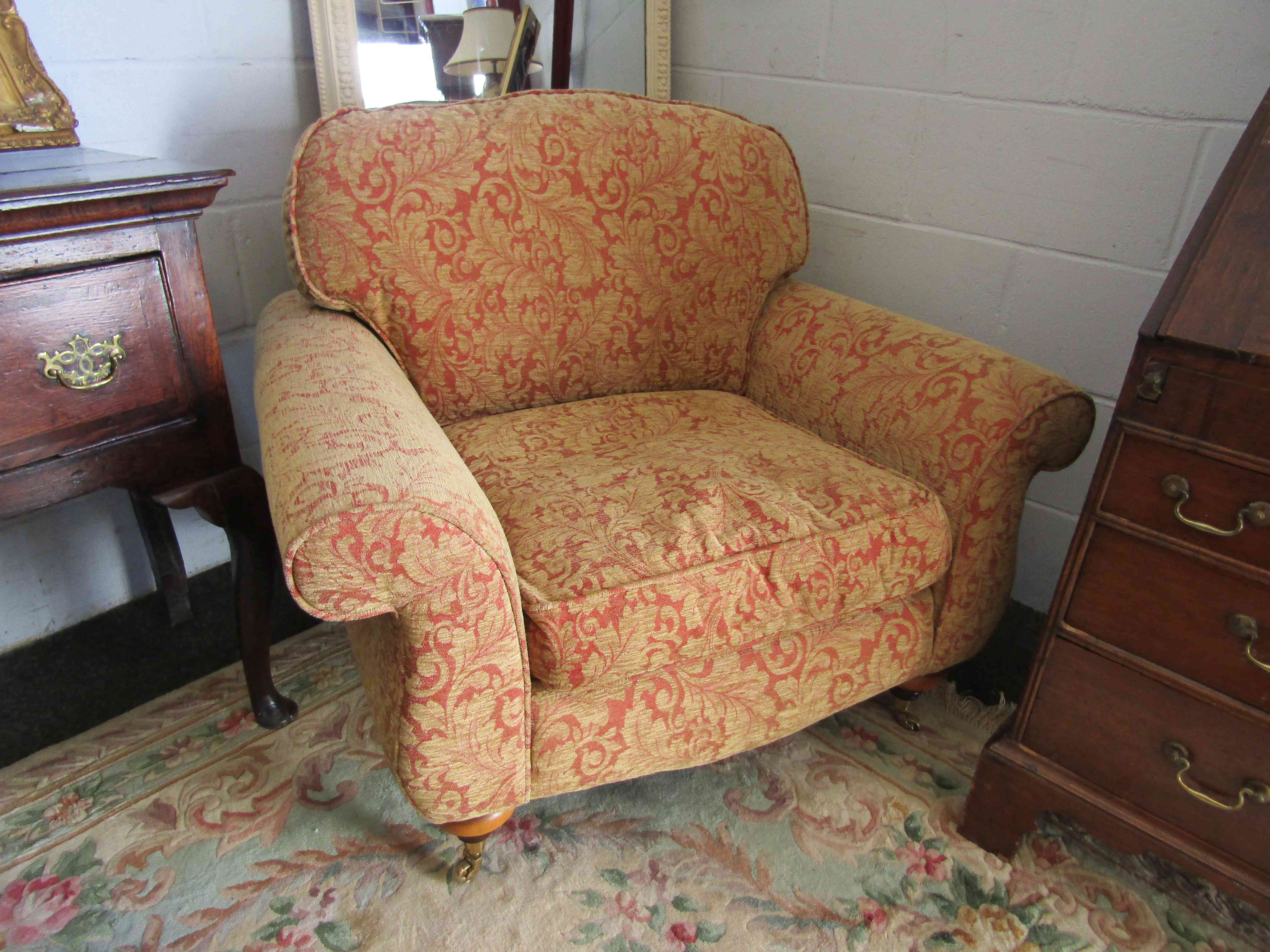 A pair of upholstered swag design armchairs on castors