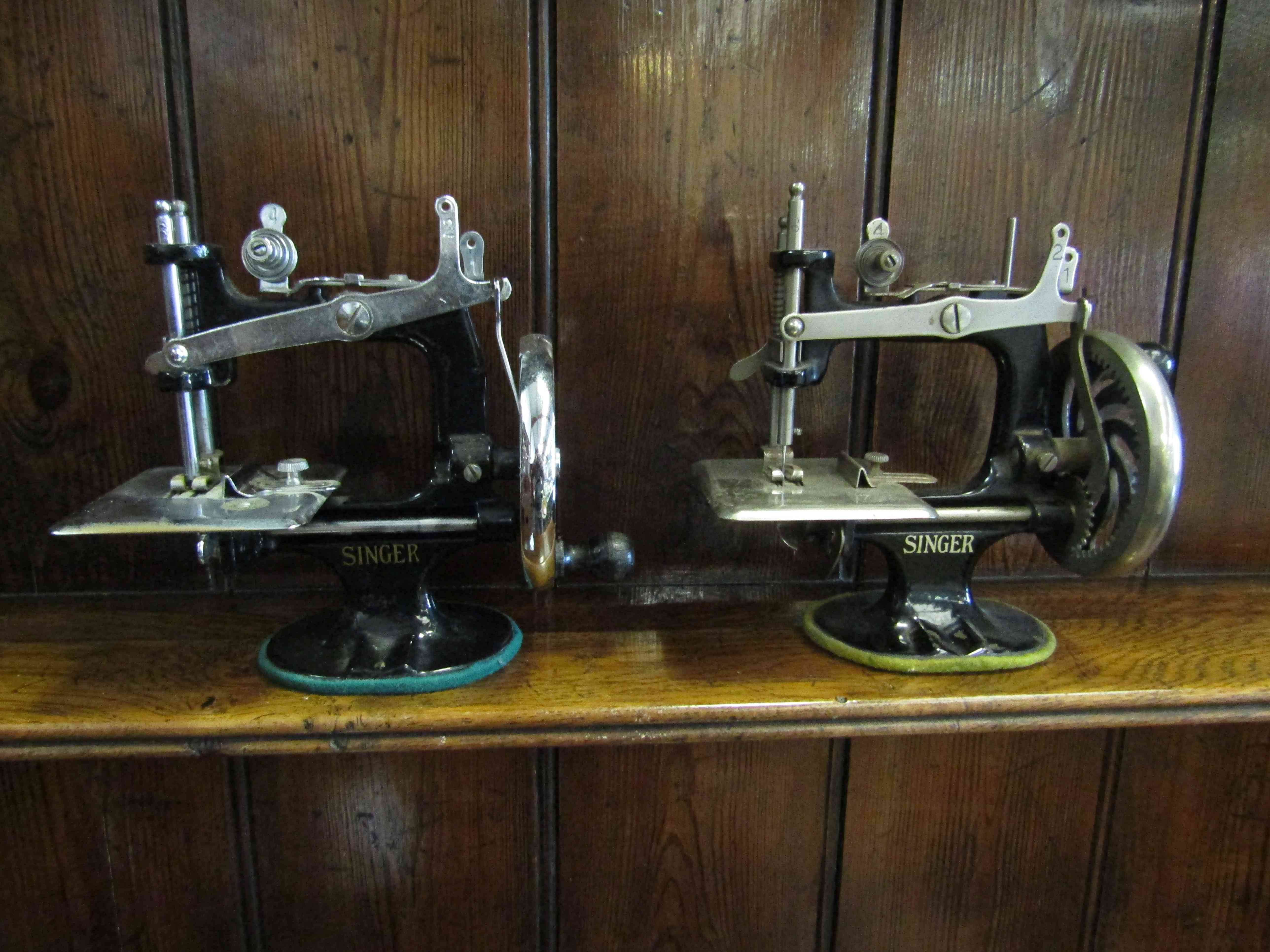 Two miniature Singer sewing machines,