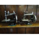 Two miniature Singer sewing machines,