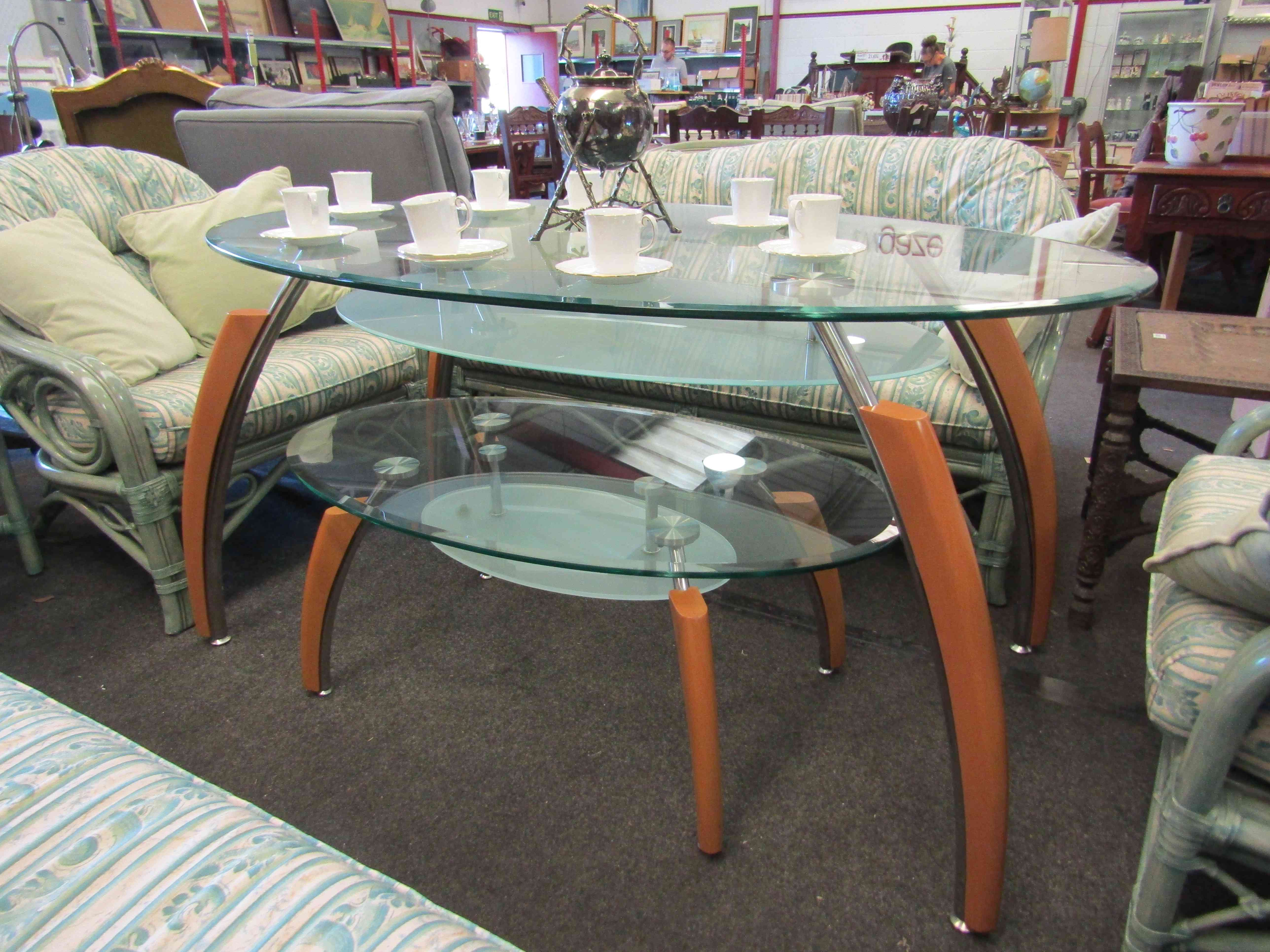 Two modern graduating glass top oval tables