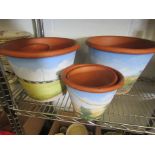 Nine modern hand painted terracotta pots of various sizes,
