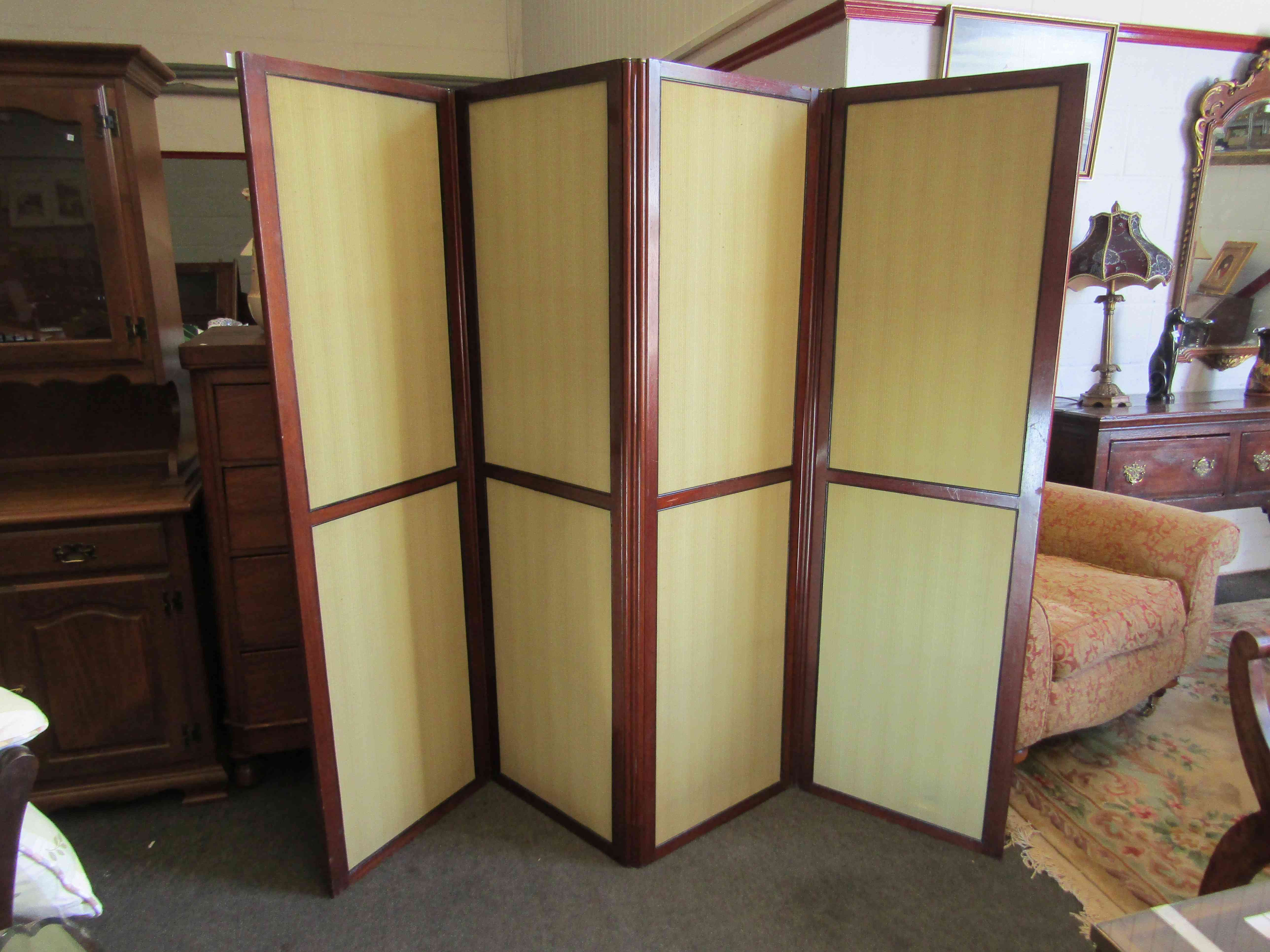 An Edwardian mahogany four fold screen with green fabric panels,